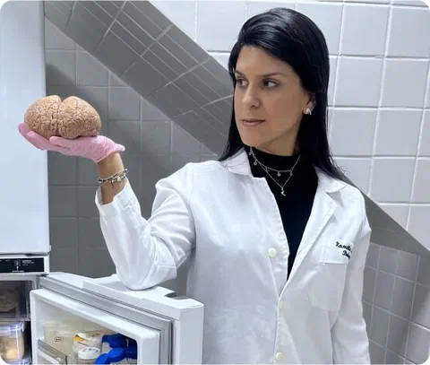 Kamilla Souza segurando um cérebro de golfinho no laboratório